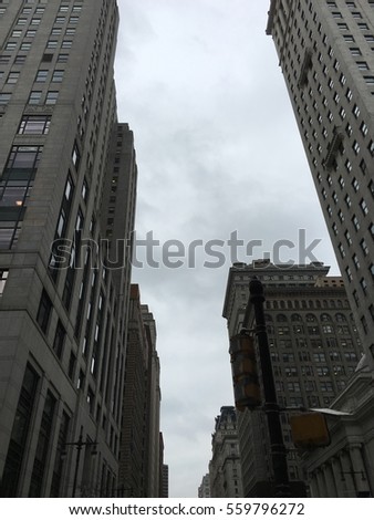 Tall stone buildings under a grey cloudy sky