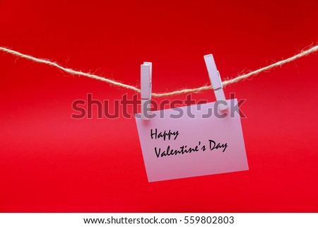 Greeting in white sheet hang on rope on red background.
