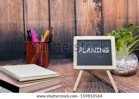 mini blackboard with text, book and wooden background