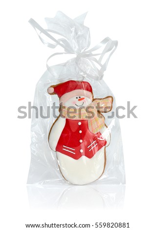 Snowman gingerbread in transparent packing with a bow. Isolated.