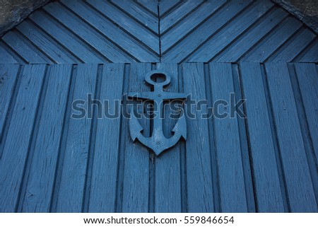 Blue anchor sign on a wooden door 