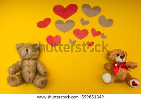 A lot of hearts and two teddy bears on the yellow background