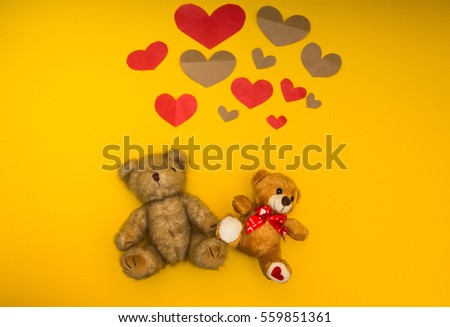 Two teddy bears on a yellow background and heart over them