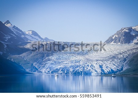 Alaskan glacier, picture of Glacier Bay,with ice reflecting in the water, with a blue tint.