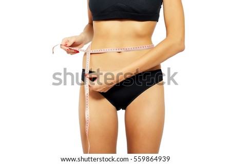 Young attractive woman measuring her hips with tape measure. Isolated on white background