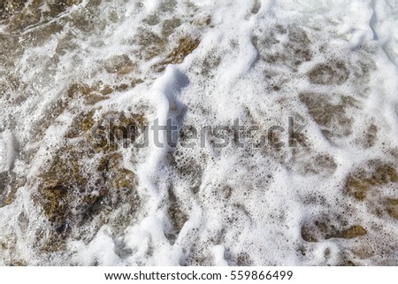 The beautiful foam waves on the rocky area of Akliman Cove. Canakkale-Turkey