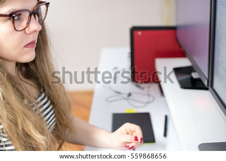 Cropped side view image of a young businesswoman with glasses bringing her expertise to design using computer at the office