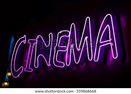Advertising neon sign on a wall/Cinema.