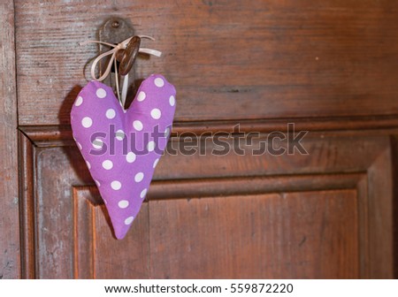Romantic purple dotted heart shape hanging on an old wood door background, lovely background for Birthday, Greeting Card, Mothers Day or Valentine.