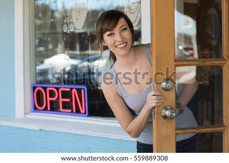 Woman peeking out front door of store