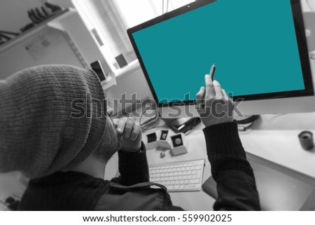 Graphic designer sits at his desk holding his digital pen and is ready to start working on his graphic design project