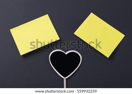 Two yellow post-it with a heart on black background