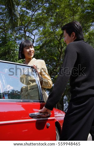 Man opening car door for woman