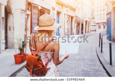 woman tourist looking at the map on the street of european city, travel to Europe Royalty-Free Stock Photo #559985464