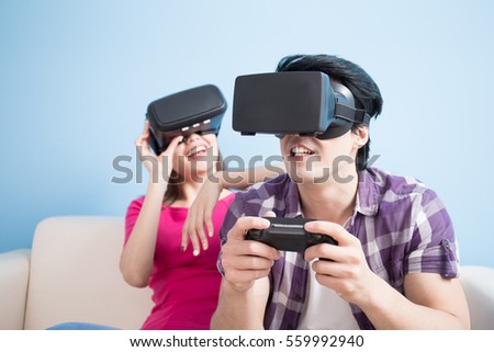 young couple play vr game isolated on blue background