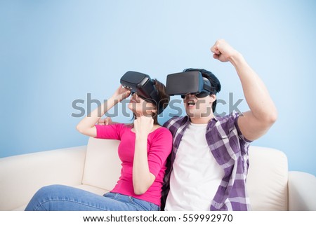 young couple watch vr game and feel ecited isolated on blue background