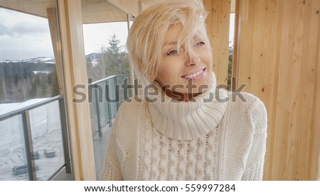 Blonde beautiful woman smiling, relaxing. Outdoor photo. Mountains.