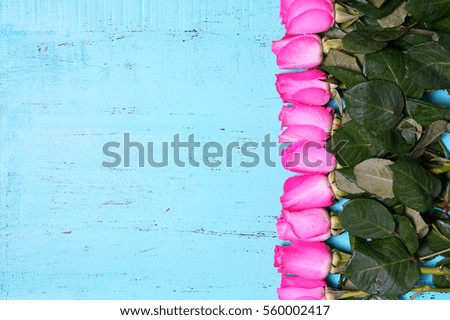 Vintage aqua blue wood background with decorated borders of pink rose buds with copy space and room for text.