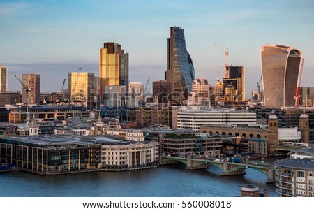 The cityscape and skyscrapers of the financial district, The City of London, including the Heron Building, the Walkie-talkie and Tower 42 landmarks. The Thames and Southwark Bridge are in the fore.