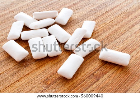 Chewing gum pieces on a wooden background Royalty-Free Stock Photo #560009440