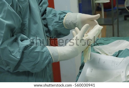 How to wear a surgical gloves in operation room Royalty-Free Stock Photo #560030941