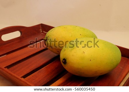 Ripe mango on wood trey, important export fruit of Thailand, popular sweet tasty fruit served with cooked sticky rice and coconut milk 