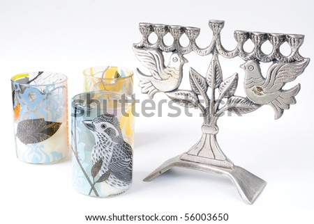 Colorful picture of a bird on a candle holder next to a menorah with peace doves.