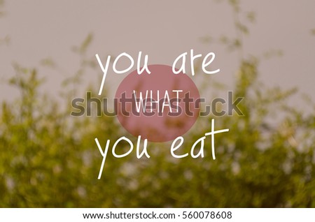 "You are what you eat" text on blurry green nature background.