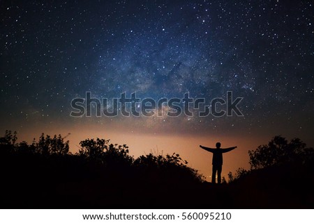 milky way galaxy and silhouette of a standing happy man on Doi Luang Chiang Dao high mountain in Chiang Mai Province, Thailand.
