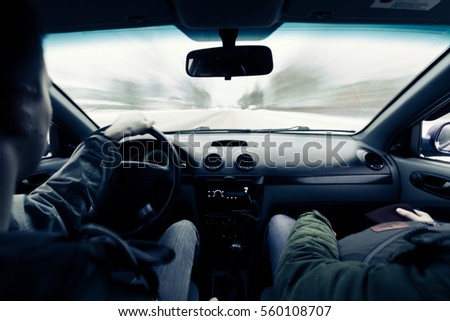 driving a car on winter road. Two people riding in a car inside view