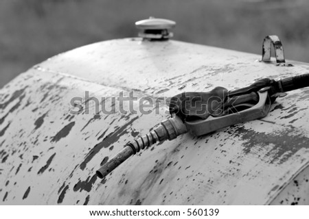 old used gas nozzle on a large rusting fuel drum - converted to black and white, color version also available.