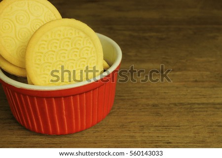 Biscuits in red bowl on wooden background