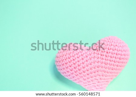 Close up pink crochet heart on green background. Love and care concepts. Valentine's day.