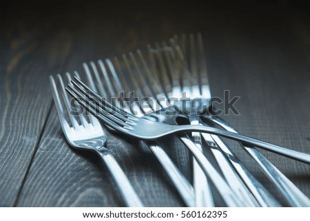 Several steel forks. Wooden background. Selective focus. Vintage style photo. 