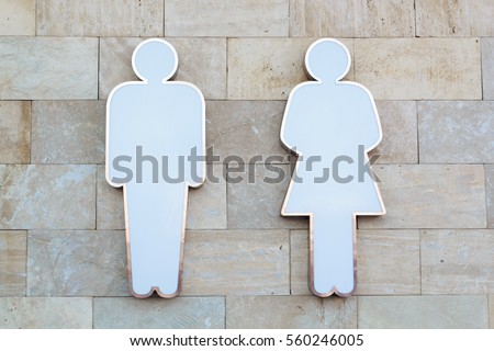 Toilet sign. Solid male and female figures on the wall of stone bricks.