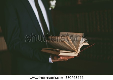 Man reading a book and looking at the pages