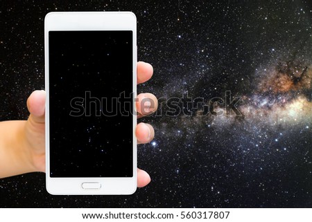 Man use mobile phone, Orion on screen and Milky Way galaxy as background.(Elements of this Image Furnished by NASA)
