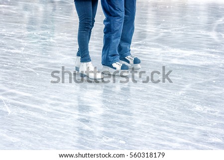 boy and girl skating on the rink. legs closeup