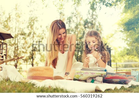 Young woman and her daughter enjoying together outdoors