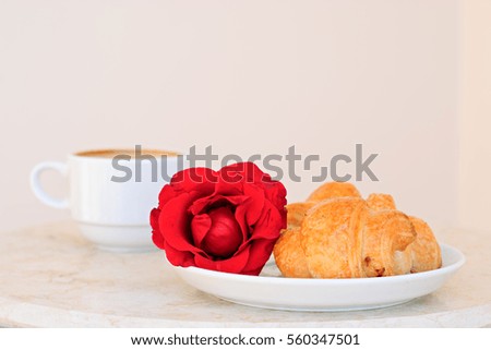 Cup of coffee, croissants and rose on table, romantic breakfast, Valentine Concept