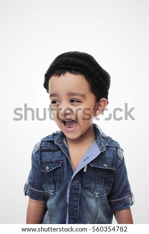 Portrait. happy little south asian boy wearing cultural hat. smiling and looking away from camera isolated on white