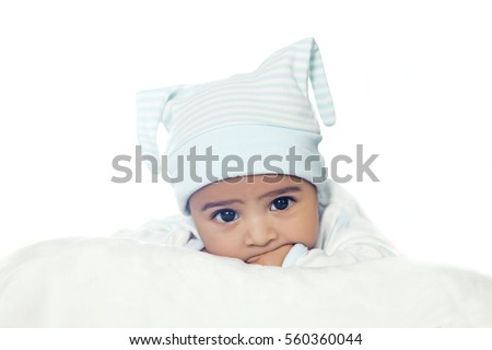 Adorable Six Month Baby Boy Wearing Blue Suite In White Bedding isolated on white