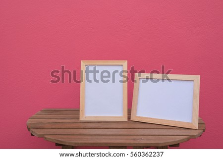 Two photo Frame on a wooden on pink background .
