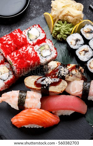 Japanese cuisine. Sushi set on a stone plate and concrete background.