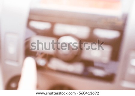 Blurred  background abstract and can be illustration to article of hand adjusting the sound volume in the car stereo
