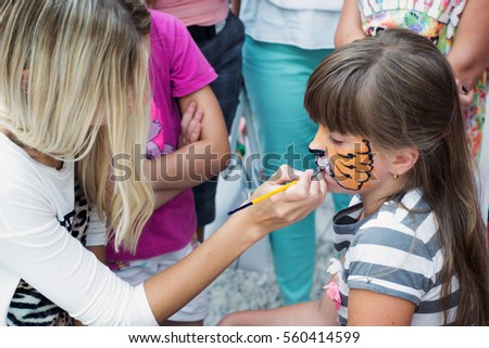 Girl does a child on the face mask of make-up for children