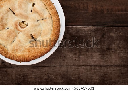 Homemade apple pie dessert shot from overhead over a white wooden table top with room for copy space.