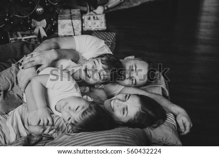 Mother, father and two sons  on the bed. Christmas. Royalty-Free Stock Photo #560432224