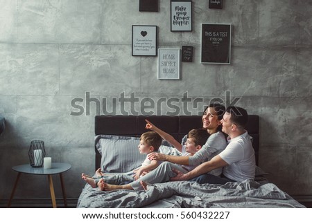 Mother, father and two sons  on the bed. Christmas. Royalty-Free Stock Photo #560432227