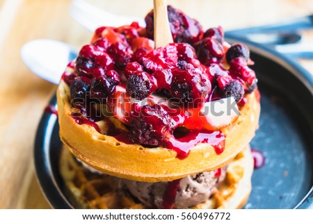 waffles and chocolate icecream with fresh berries on wooden tray